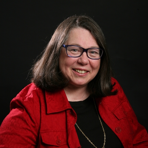 A woman in a red jacket and glasses
